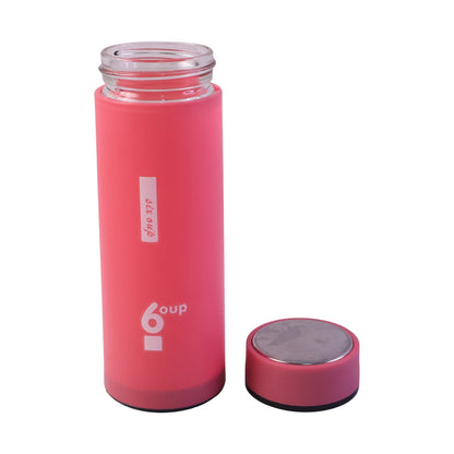 Person drinking water from glass bottle with silicone sleeve