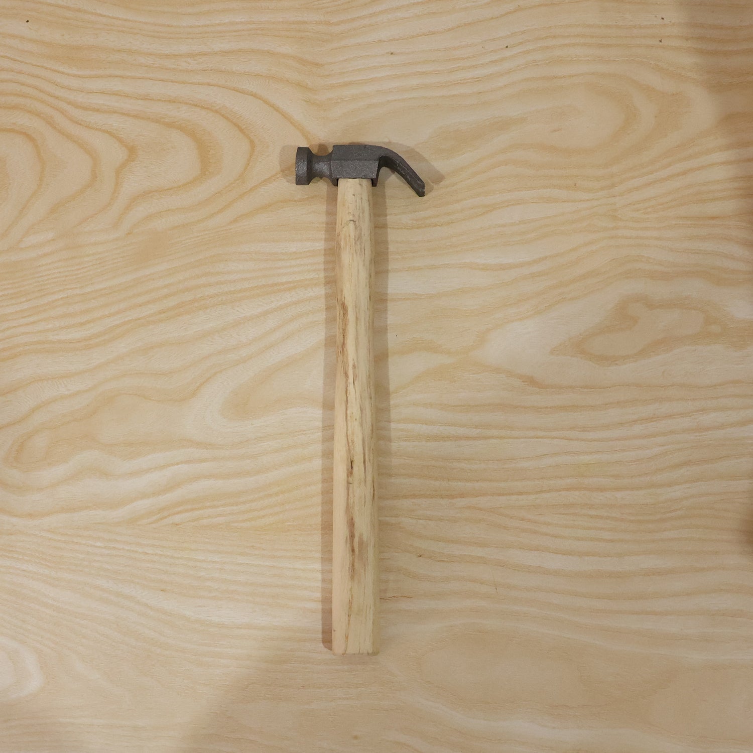 Person using claw hammer to drive a nail in carpentry