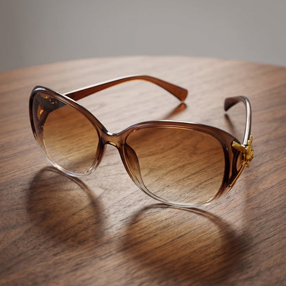 Fashionable oversized sunglasses for women with gradient lenses and gold floral temples.