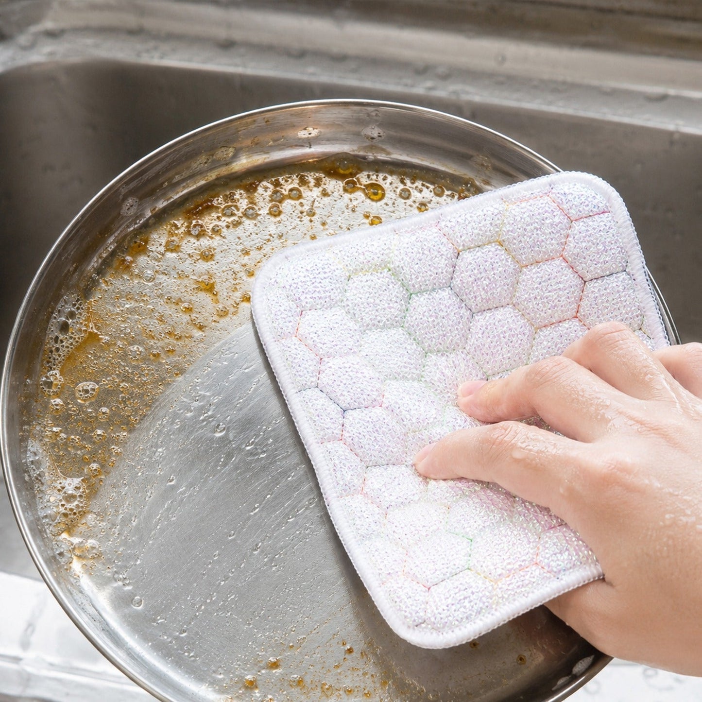Kitchen utensils cleaning scrub pad in use