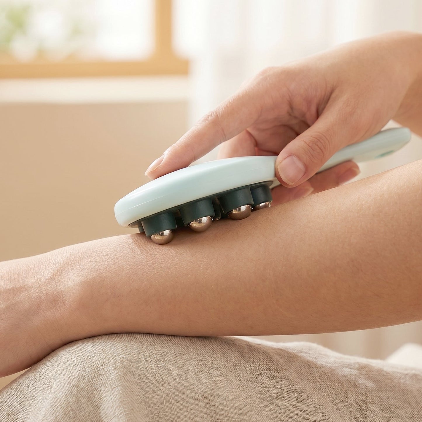 User applying steel ball massager to shoulder for muscle relief.