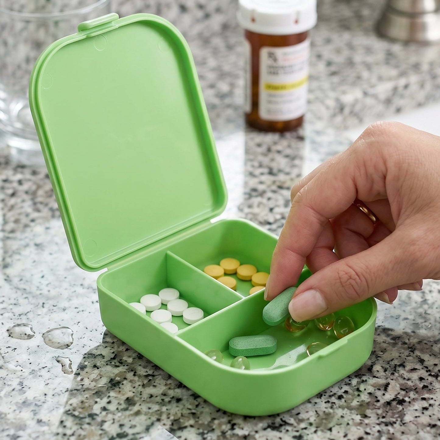 Hand holding a portable pill organizer box for travel.