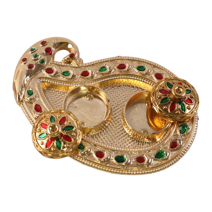 Golden Kankavati holder in use during a pooja ceremony