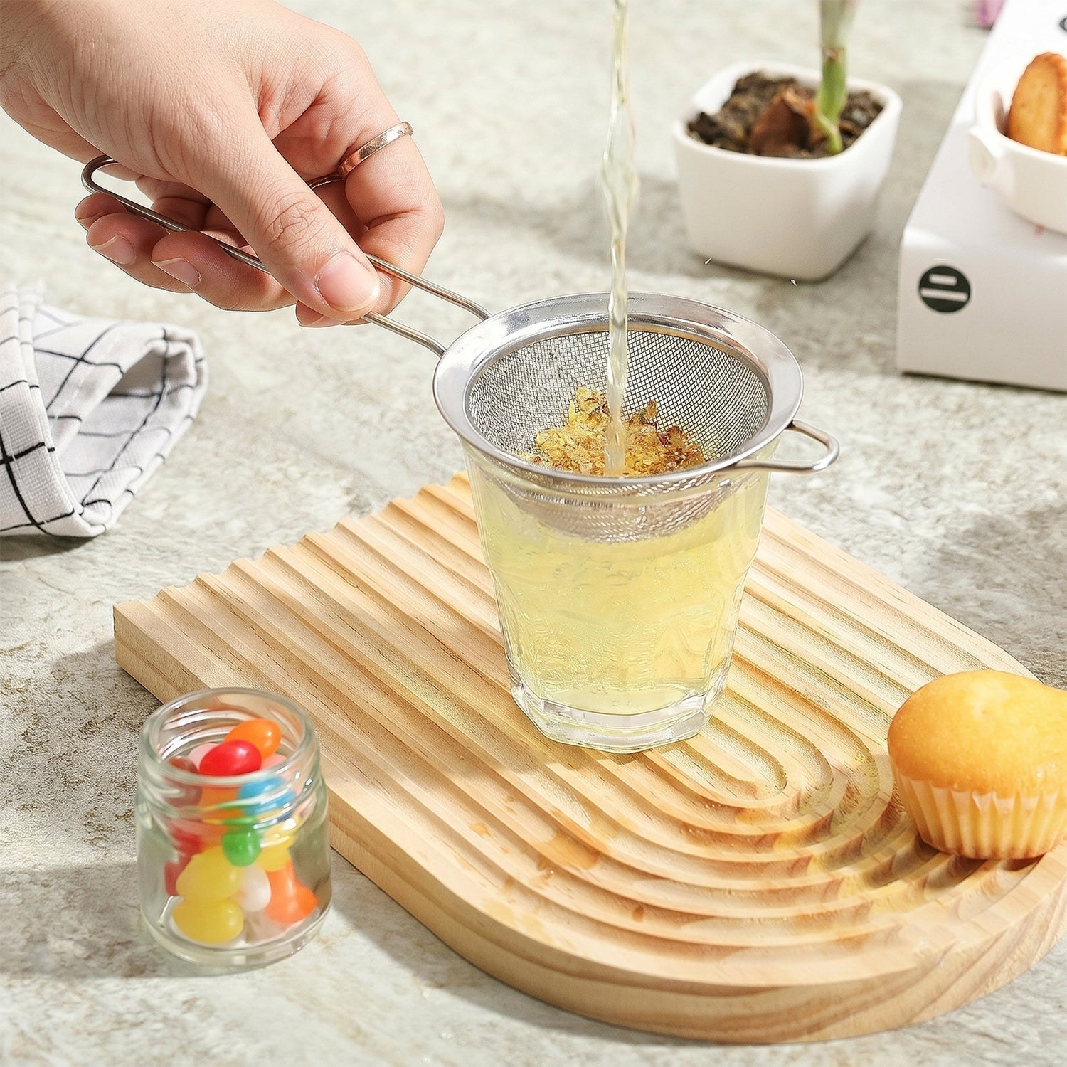 Fine mesh sieve filtering tea into a cup