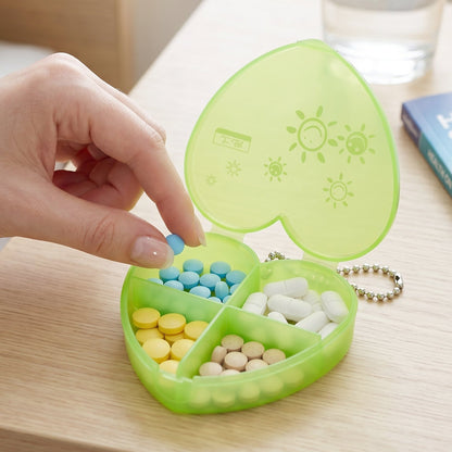 Compact pill organizer held in hand showing four compartments