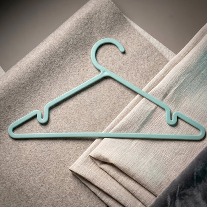 Plastic hanger holding shirt and dress, supporting heavy fabrics