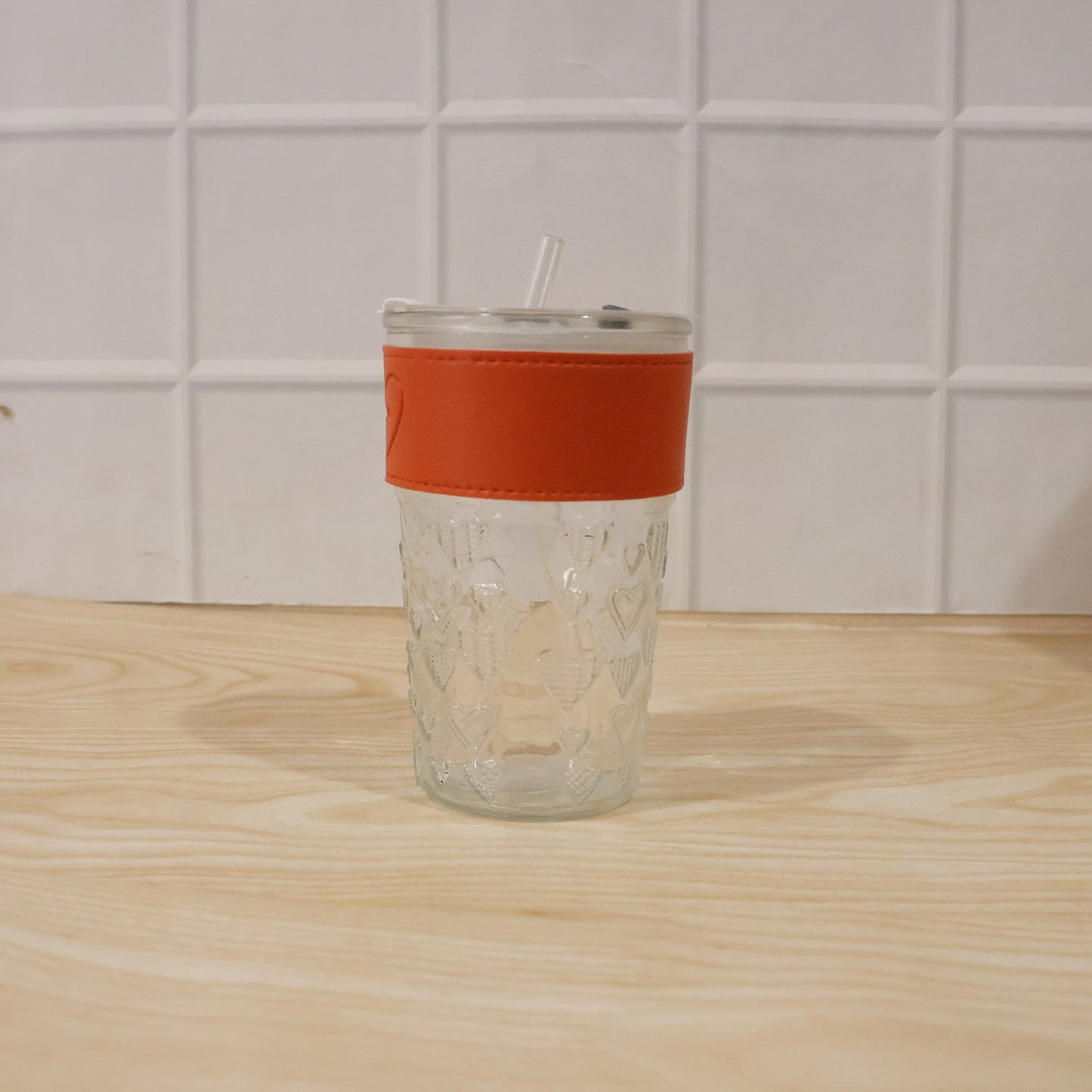 Hand holding glass tumbler with lid, perfect for daily hydration